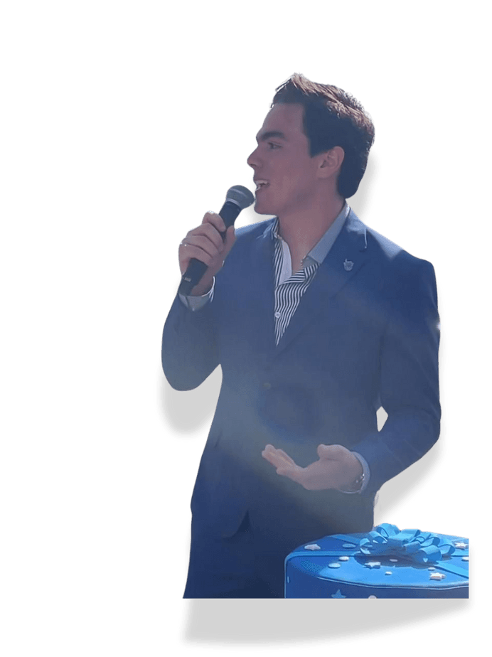 Ari Emilio Núñez hablando con micrófono en un evento estudiantil